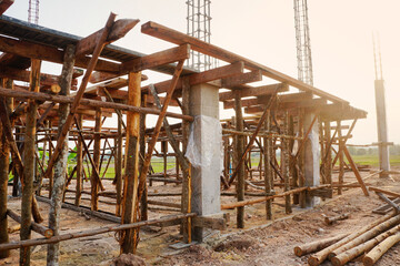 Fototapeta na wymiar Temporary poles and wooden scaffolding support concrete beams at the house construction site.