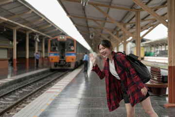 Obraz premium Happy asia woman traveller feeling happiness before go to travel at the train station, summer travel and lifestyle concept
