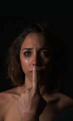 Woman crying and a man's hand silencing her mouth, a scene of gender violence. Domestic violence.