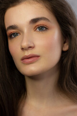 Obraz premium Close-up beauty woman with clean shiny skin and natural cosmetics. Fashion, spa, cosmetology, lip injections, eyeshadow on brown eyes and thick eyebrows, cosmetics, make-up, beautiful