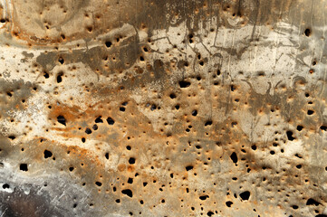 holey rusty metal background. holes from bomb fragments on metal. iron rusty background. bullet holes in a metal plate