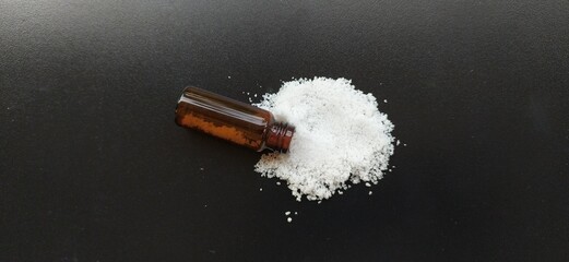 Fallen bottle of pure white Cocaine heroin powder isolated and scattered sprinkle cocaine pile with...