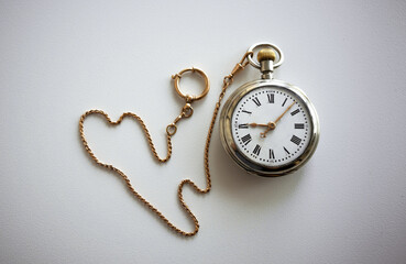 Vintage pocket watch with gold chain on white isolate. Mechanical watch with chatelaine made of gold on a white table.The passing time. - Powered by Adobe