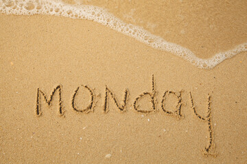 Monday - handwritten on the light beach sand with a soft wave lapping.