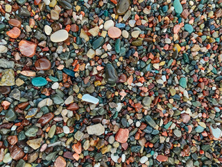 Set of beautiful colorful stones with different pattern polished by the sea. Textured background of minerals and crystals on the beach. Abstract nature background with colorful pebble stones.