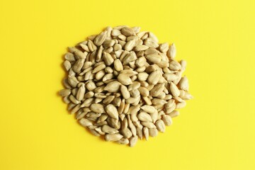 Peeled sun flower seeds photo isolate on yellow background top view