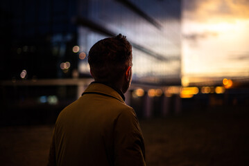 Man silhouette unrecognizing person successful businessman enjoying the sunset near city...