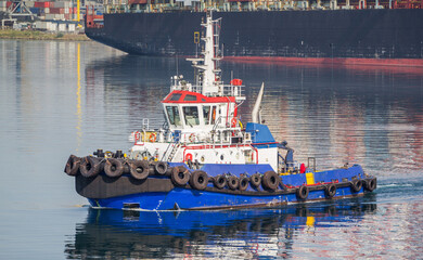 Tug at the seaport. Towing operation in the port