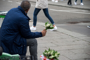Portrait on back view of romanian man selling lilly of the valey flowers in the street