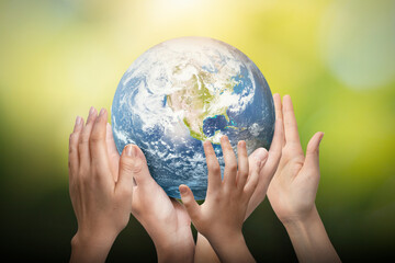 Earth globe in family hands. World environment day. Elements of this image furnished by NASA