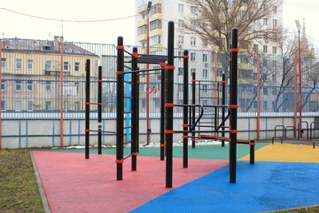 Fototapeta na wymiar Modern workout outdoor fitness, crossfit and sport playground area with exercise equipment at public park. Active sport, training, gym and healthy lifestyle concept. Urban style street sport station