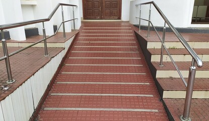 Old dirty concrete ramp way wheelchair stair path in building with stainless steel handrail railing...