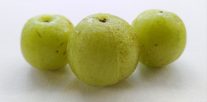 Bunch of healthy three organic farm fresh tropical fruit wet gooseberries with water drops isolated on white table background surface with copy space. beautiful horizontal closeup macro side view.