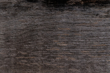 Fototapeta premium Background image of dark wood texture with a fibrous uneven structure.