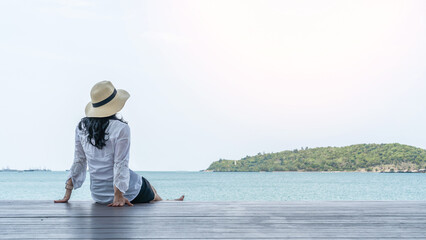 Summer relaxation of asian woman take it easy happily sitting resting on pier or sea deck...