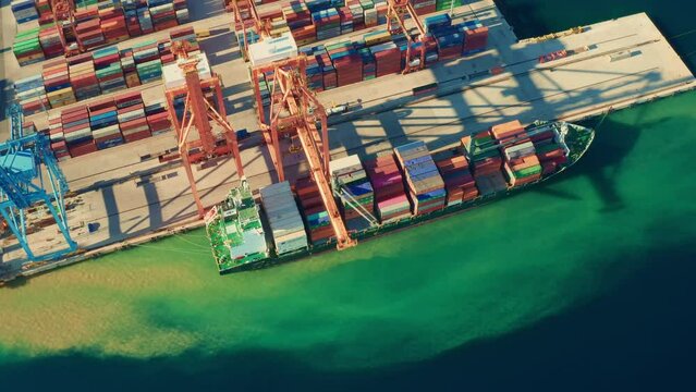 Aerial view of containers loading and unloading to the ship in the sea port. Logistic and transportation of goods. Crisis and shortage of containers in the world, April 2022, Rijeka, Croatia.