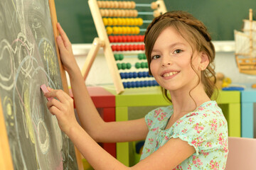 happy student girl drawing on blackboard