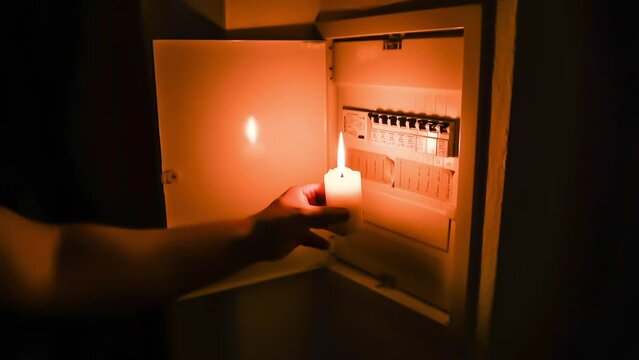 Filmmaterial mit Ton eines Sicherungskasten mit Sicherungen wird von einem Mann w&auml;hrend eines Stromausfall mit brennender Kerze beleuchtet und ge&ouml;ffnet, Deutschland