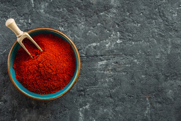 Chili pepper powder on dark background with copy space top view