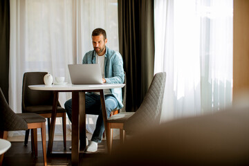 Young man using laptop and drink tea in the living room