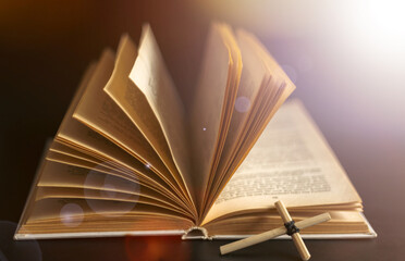 Homemade cross on an open Holy Bible book. Cross in open Bible.