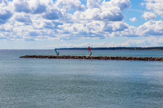 Two men are surfing on a summer day at the sea. Elsinore, Denmark - June 28, 2021