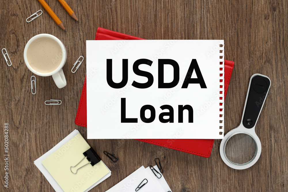 Poster usda loan notepad on the background of a wooden table. text on white paper of a red notepad near a m