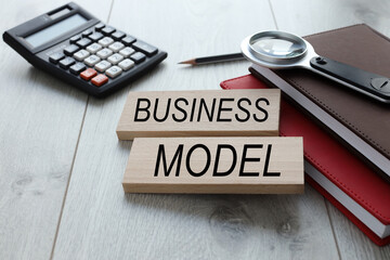 Business model text on wooden blocks on different notebooks