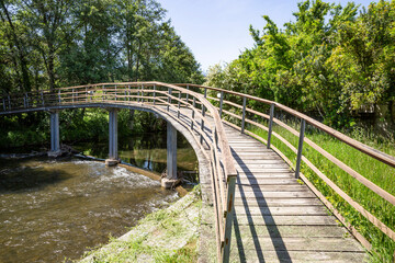 Fototapeta na wymiar pedestrian wooden bridge over ribeira de Pera River at Mosteiro Schist village (Vila Facaia), Pedrógão Grande, Leiria, Portugal
