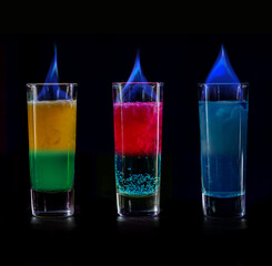 Cocktails Party Shots and Shooters on bar counter in a restaurant, pub. Miniature mixed drinks. Alcoholic cooler beverage at nightclub on dark background