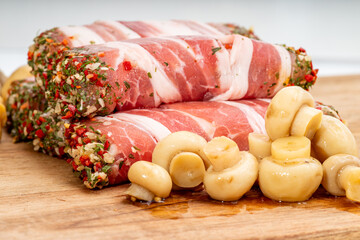 Bacon-wrapped meat roll with spices and herbs. Jamon pork, prosciutto, or presunto meat products,...