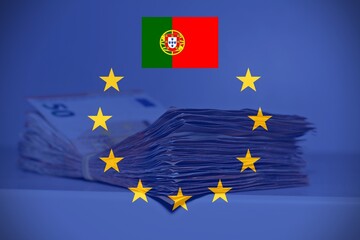 Obraz na płótnie Canvas Pile of fifty euros on the table with the European Flag and the Portuguese Flag, concept of financial help to Portugal