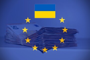 Pile of fifty euros on the table with the European Flag and the Ukrainian Flag, concept of financial help to Ukraine