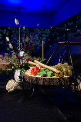 assorted cheese and grapes on a wooden stand at the event