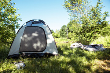 Installed tourist tent in a camping in nature in the forest. Domestic tourism, active summer...