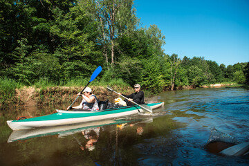 Family kayak trip. An elderly married couple rowing a boat on the river, a water hike, a summer...