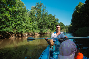 Family kayak trip. Father and daughter rowing boat on the river, a water hike, a summer adventure. Eco-friendly and extreme tourism, active and healthy lifestyle