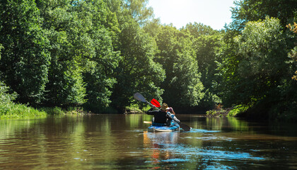 Man and woman couple in family kayak trip rowing boat on the river, a water hike, a summer...