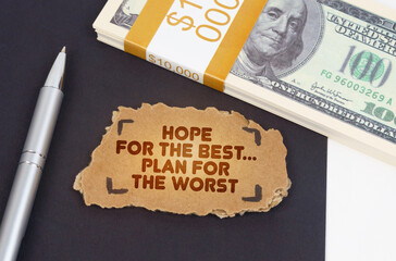 On the table are dollars, a pen and a cardboard sign with the inscription - Hope for the best plan...