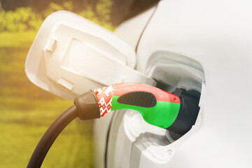 Fototapeta premium Charging electric vehicles using an electric cable with the image of the flag of Belarus