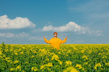 woman in yellow hoodie, cap and sunglasses in rapeseed field
