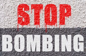 On the white-gray surface of the wall is the inscription - Stop Bombing