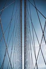 Abstract lines of cable of a bridge forming symetrical pattern on a blue sky background, peaceful...