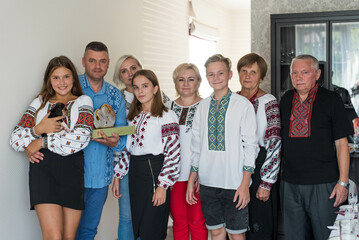 Happy family in Ukrainian national clothes on home background. No war, save Ukraine, stop russian...