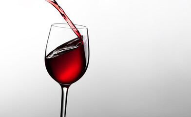 Glass with red wine on a gray background