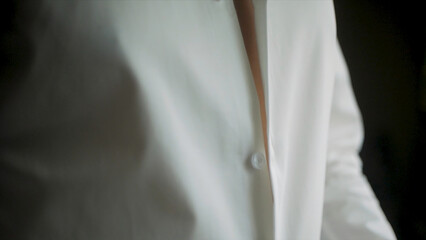 Close up of businessman wears a white shirt. Clip. Close up of man dressing up and adjusting white...