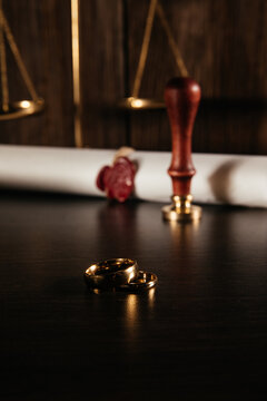 Two golden wedding rings and divorce decree document. Divorce and separation concept. Vertical image