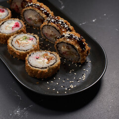 Tempura with eel and shrimp. Tempura roll with fried shrimps, eel, curd cheese and cucumber. Poured with unagi sauce.