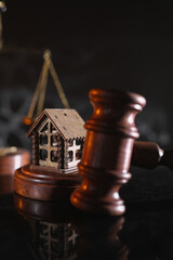 Concept of suing for property. Wooden gavel with house close-up