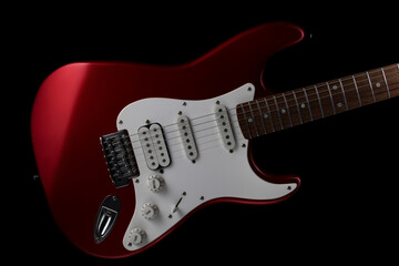 Red electric guitar on a black background. Fender